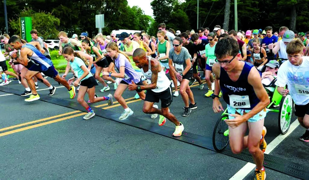 Runners, sprint from the start line of a road race.